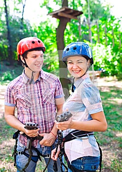 Adventure climbing high wire park - people on course in mountain helmet and safety equipment