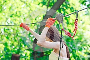 Adventure climbing high wire park - people on course in mountain helmet and safety equipment.