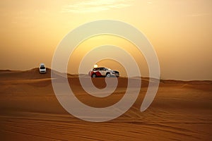 Adventure desert safari on sand dunes with off road vehicles at sunset