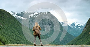 Adventure, fun and freedom with a female hiker enjoying the view while hiking outdoors in nature. Rearview of a woman