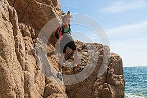 Adventure girl climbs on a cliff, rich the target