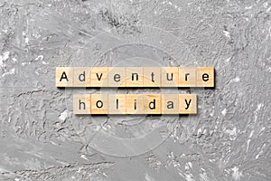 Adventure holiday word written on wood block. adventure holiday text on cement table for your desing, concept