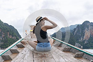 Adventure lifestyle vacationer relax concept. Traveler young woman wear hat sitting on long tail boat floating lagoon with