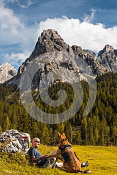 Adventure Man and Dog Trekking Trip Outdoor in Scenic Dolomites Mountains