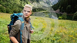 Adventure man hiking wilderness mountain with backpack