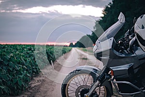 Adventure Motorcycle standing on a dirt road at the suset, off road travel concept, enduro rider equipment, extreme lifestyle,