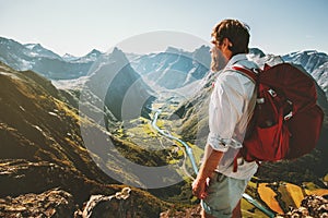 Adventure in mountains Man with red backpack alone on cliff