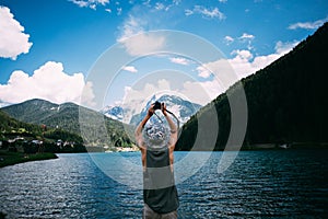 Adventure seeker man makes photo of lake