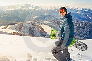 Adventure to winter sport. Snowboarder man hiking at mountain