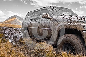 Adventure travel concept background. 4x4 off-road suv car stuck in mud.