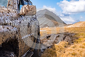 Adventure travel concept background. 4x4 off-road suv car stuck in mud.