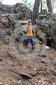 Adventure and travel. a little boy with a backpack is walking along a forest path. hiking with children