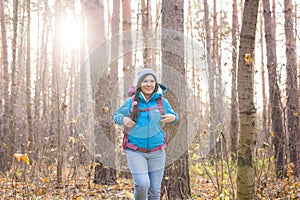 Adventure, travel, tourism, hike and people concept - Attractive smiling tourist woman walking in the thick of the