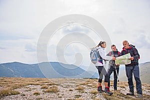 Adventure, travel, tourism, hike and people concept - group of smiling friends with backpacks and map outdoors