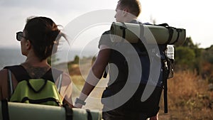 Adventure, travel, tourism, hike and people concept. Rare footage of a couple hiling the hills together with backpacks