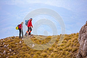 Adventure, travel, tourism, hike and people concept - smiling couple walking with backpacks outdoors