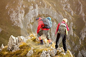 Adventure, travel, tourism, hike and people concept - smiling couple walking with backpacks outdoors