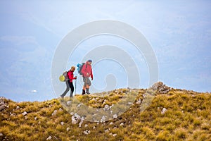 Adventure, travel, tourism, hike and people concept - smiling couple walking with backpacks outdoors