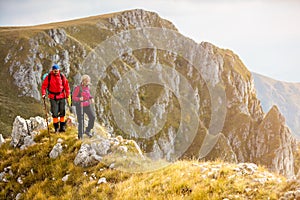 Adventure, travel, tourism, hike and people concept - smiling couple walking with backpacks outdoors