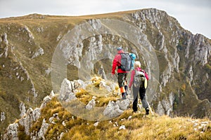 Adventure, travel, tourism, hike and people concept - smiling couple walking with backpacks outdoors