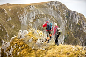 Adventure, travel, tourism, hike and people concept - smiling couple walking with backpacks outdoors