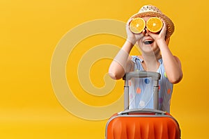 Adventure travel trip concept. Cheerful funny happy cute little girl with a suitcase and an orange instead of eyes.