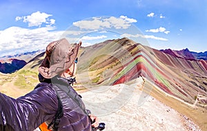 Adventure traveler guy taking selfie at Rainbow Mountain on Vinicunca mount during roadtrip travel experience in Peru photo