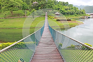 Adventure wooden rope suspension bridge crossing river