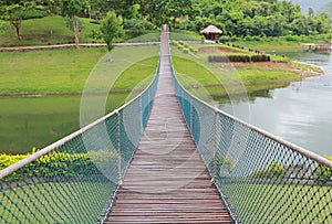 Adventure wooden rope suspension bridge crossing river