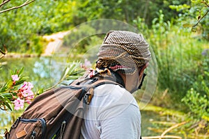 Adventurer man with backpack hiking in nature