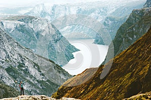 Adventurer Man raised hands traveling at Naeroyfjord