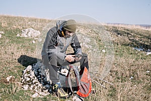 Adventurer man resting on rock with mountain walkie-talkie