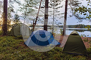 Adventures Camping tourism and tent under the view forest landscape near water outdoor in summer evening and sunset sky. Camping