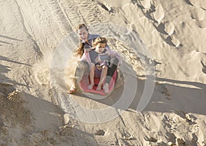 Adventuresome girls boarding down the Sand Dunes photo