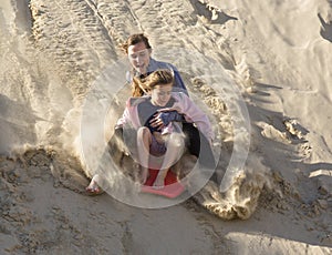 Adventuresome girls boarding down the Sand Dunes photo
