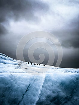 Adventuring hikers on a glacier on a cloudy day photo
