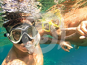 Adventurous best friends taking selfie snorkeling underwater