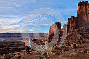 Adventurous couple hiking in desert by red sandstone walls.