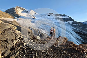 Adventurous couple hiking in mountains at the base glacier.