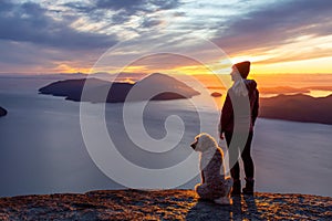 Adventurous Girl Hiking on top of a Mountain with a dog