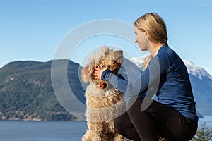 Adventurous Girl Hiking on top of a Mountain with a dog