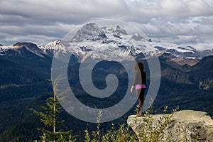 Adventurous Girl near a cliff enjoying the Beautiful Canadian Nature photo