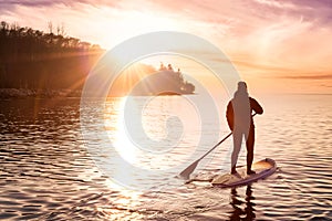 Adventurous girl on a paddle board is paddeling in the Pacific West Coast Ocean