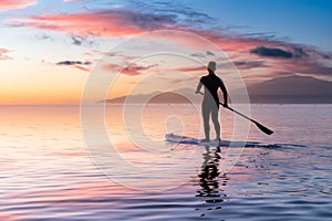 Adventurous girl on a paddle board is paddeling in the Pacific West Coast Ocean