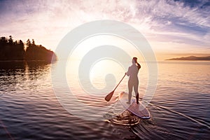 Adventurous girl on a paddle board is paddeling in the Pacific West Coast Ocean