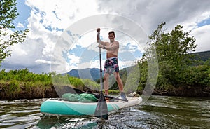 Adventurous Hispanic Adult Athletic Man paddle boarding