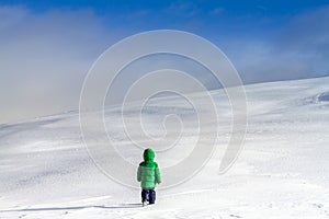 An adventurous little boy walking near the clouds on the high mountains