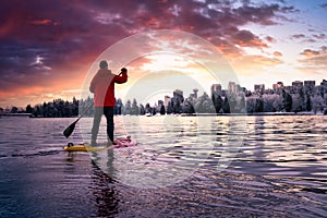 Adventurous male is paddle boarding near Stanley Park