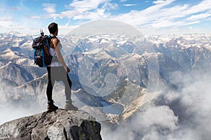 Adventurous Man Hiker on top of a Steep Rocky Cliff