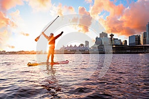 Adventurous man is paddle boarding near Downtown City